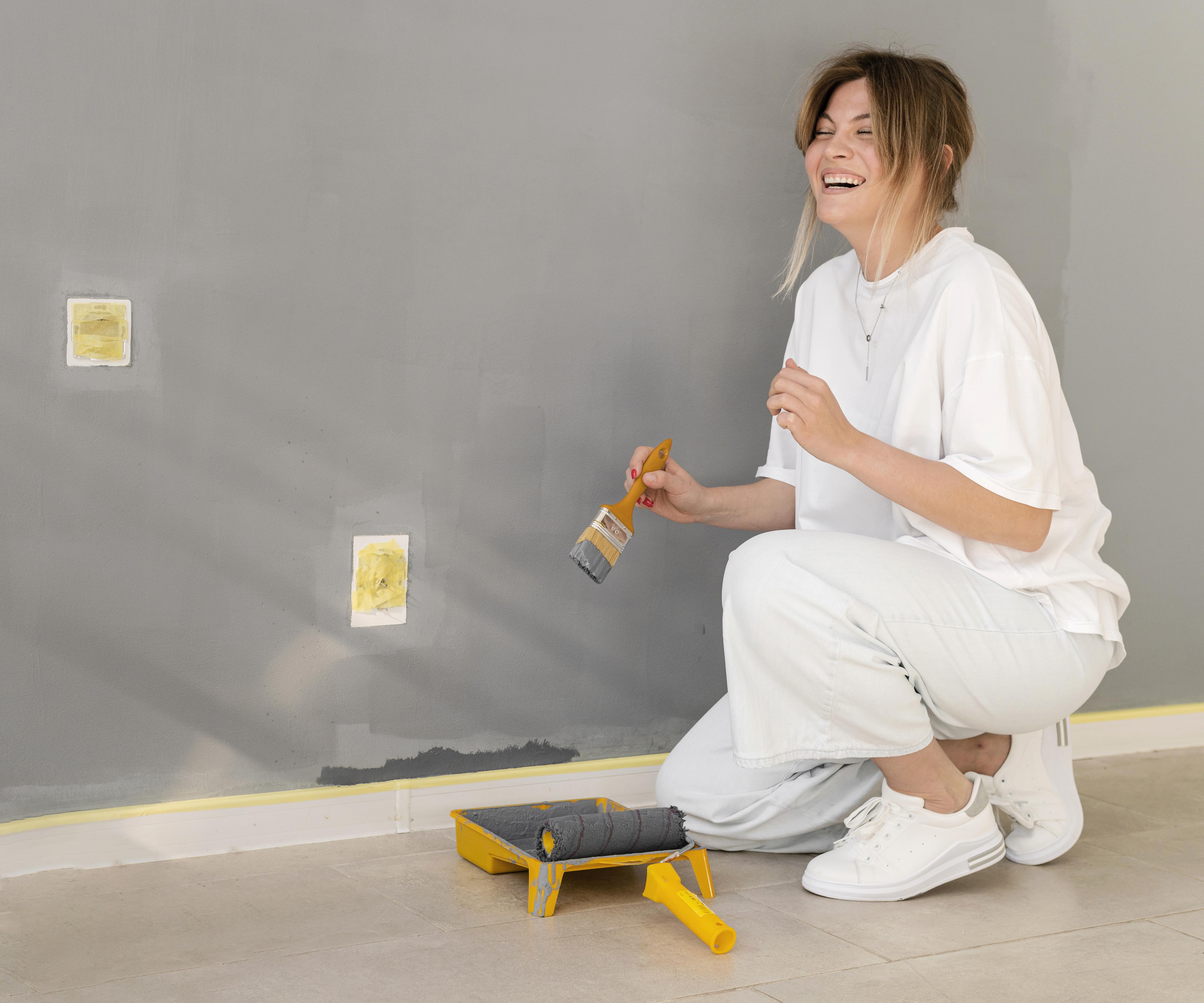 mujer pintando casa